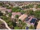 A neighborhood showing the houses with tile roofs and solar panels with palm trees in desert landscape at 1839 Thunder Mountain Dr, Henderson, NV 89012