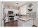 Modern kitchen featuring white cabinetry, granite countertops, and stainless steel appliances at 1839 Thunder Mountain Dr, Henderson, NV 89012