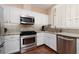 Well-equipped kitchen with granite counters, stainless steel appliances, and white cabinets at 1839 Thunder Mountain Dr, Henderson, NV 89012