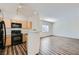 Kitchen showcasing black appliances, light wood cabinets, and wood-look floors open to living area at 1881 W Alexander Rd # 1092, North Las Vegas, NV 89032