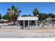 Front exterior view shows the home, palm trees, and a small wall enclosing the front yard at 192 W Alma Ave, Overton, NV 89040