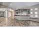 An entertainment bar area with gray cabinets, glass door uppers and unique stone countertops at 2017 Slow Wind St, Las Vegas, NV 89134