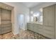 Bathroom with beautiful stone floors, vanity with granite counters, and custom cabinetry at 2017 Slow Wind St, Las Vegas, NV 89134
