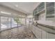 A living area featuring tile floors, modern gray cabinets and sliding glass doors leading to a patio at 2017 Slow Wind St, Las Vegas, NV 89134