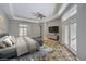 Staged main bedroom with outside access, tray ceilings, ceiling fan and large TV at 2017 Slow Wind St, Las Vegas, NV 89134