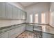 Spacious office area with gray cabinets, stone countertops and natural light from three windows at 2017 Slow Wind St, Las Vegas, NV 89134