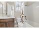 Bright bathroom features a vanity with a dark wood cabinet, shower and white tile at 251 Castellari Dr, Las Vegas, NV 89138