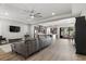 Open-concept living room with wood floors, modern ceiling fan, and seamless flow into the kitchen at 251 Castellari Dr, Las Vegas, NV 89138