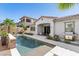 Backyard oasis with an in-ground pool, mosaic waterfall, and a comfortable egg chair for relaxation at 251 Castellari Dr, Las Vegas, NV 89138