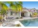 Beautiful in-ground pool with mosaic waterfall and swaying palm trees, creating a relaxing backyard paradise at 251 Castellari Dr, Las Vegas, NV 89138