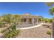 Spacious backyard featuring a covered patio, low-maintenance desert landscaping, and mature trees at 2535 Leighton Ave, Henderson, NV 89052