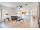 Inviting living room with neutral tile flooring, ceiling fan, and seamless flow to kitchen and dining area at 2535 Leighton Ave, Henderson, NV 89052
