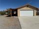 Attached two-car garage with a white door and a covered breezeway providing sheltered access to the home at 3090 N Woodchips Rd, Pahrump, NV 89060