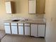 Kitchenette featuring tile countertops, white cabinets, and a built in sink at 3090 N Woodchips Rd, Pahrump, NV 89060