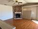 Cozy living room featuring a stone fireplace and hardwood floors at 3090 N Woodchips Rd, Pahrump, NV 89060