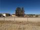 A wide view of the property showing the house, garage, and desert landscape at 3090 N Woodchips Rd, Pahrump, NV 89060