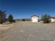 Expansive lot featuring a detached garage/workshop and desert landscaping at 3090 N Woodchips Rd, Pahrump, NV 89060