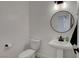 Modern powder room with a pedestal sink, round mirror, and minimalist design at 3310 Hillside Garden Dr, Las Vegas, NV 89135