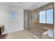 Modern shower with glass enclosure, bench, and stone floor at 3310 Hillside Garden Dr, Las Vegas, NV 89135