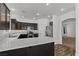 This kitchen features stainless steel appliances, dark cabinets, and granite countertops, open to the living room at 3632 Julia Waldene Ct, Las Vegas, NV 89129