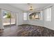 An open living room with wood-look floors, large windows, and sliding glass doors for outdoor access at 3632 Julia Waldene Ct, Las Vegas, NV 89129