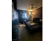 Interior shot of a dark bedroom with a ceiling fan and a window with curtains at 4238 Rollingstone Dr, Las Vegas, NV 89103