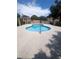 Community pool with clear blue water, surrounding patio, and security fencing at 4238 Rollingstone Dr, Las Vegas, NV 89103