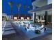 Modern poolside area with sleek lounge chairs, a unique water feature, and palm trees at night at 4381 W Flamingo Rd # 1905, Las Vegas, NV 89103