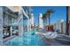 Poolside with comfortable lounge seating, palm trees, and a view of a contemporary building at 4381 W Flamingo Rd # 1905, Las Vegas, NV 89103