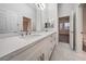 This bathroom features a double sink vanity, and a large mirror and doorway to the bedroom for convenience at 4664 Stuttgart St, Las Vegas, NV 89147
