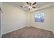 This bedroom features neutral walls, carpeted floors, a large window, and a ceiling fan for optimal comfort at 4664 Stuttgart St, Las Vegas, NV 89147