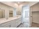 Bright bathroom features double sinks with white cabinets and a walk-in closet at 545 Thea St # 1315, Henderson, NV 89052