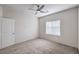 This bedroom has neutral carpet, a fan, and one large window at 545 Thea St # 1315, Henderson, NV 89052