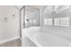 Bright bathroom featuring a tub, glass shower, and an arched window at 5505 Verbena Creek Ct, Las Vegas, NV 89131