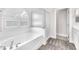 Bright bathroom featuring a tub, glass shower, and an arched window at 5505 Verbena Creek Ct, Las Vegas, NV 89131