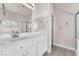 Bathroom featuring dual mirrors, white cabinets, tile floors, and a shower at 5505 Verbena Creek Ct, Las Vegas, NV 89131