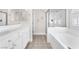 Bright bathroom featuring tub, glass shower, double vanity, and tile flooring at 5505 Verbena Creek Ct, Las Vegas, NV 89131