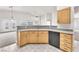 Open kitchen with light wood cabinets, stone countertops, and stainless dishwasher at 5505 Verbena Creek Ct, Las Vegas, NV 89131