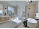 Bright bathroom featuring a soaking tub, modern chandelier, glass shower, and double sinks at 5573 San Florentine Ave, Las Vegas, NV 89141