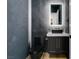 Modern powder room with dark wall treatment, black toilet, and illuminated mirror at 5573 San Florentine Ave, Las Vegas, NV 89141