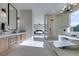 Bright bathroom featuring a soaking tub, glass shower, modern chandelier, and sink at 5573 San Florentine Ave, Las Vegas, NV 89141