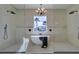 Bright bathroom featuring a soaking tub between two glass showers and a modern chandelier at 5573 San Florentine Ave, Las Vegas, NV 89141