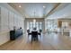 Bright dining room featuring wood-look floors, paneling, modern light fixture, and glass doors leading to the backyard at 5573 San Florentine Ave, Las Vegas, NV 89141