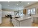 Open-concept kitchen with center island, stainless steel appliances, and views of dining and seating areas at 5573 San Florentine Ave, Las Vegas, NV 89141