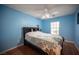 Blue bedroom with wood floors, a ceiling fan, and a large window at 5600 Old Stable Ave, Las Vegas, NV 89131