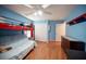 Bright blue bedroom with bunkbeds, dresser, and wood laminate flooring at 5600 Old Stable Ave, Las Vegas, NV 89131