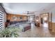Comfortable living room with wood paneling, an oversized sofa, and an adjacent dining area at 6 Montana Way, Henderson, NV 89015