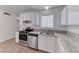 Kitchen with stainless steel appliances, granite countertops, and sleek white cabinetry at 6204 Parsifal Pl, Las Vegas, NV 89107