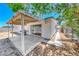Back patio with covering, sliding glass door, grill, and access to the side yard at 6204 Parsifal Pl, Las Vegas, NV 89107