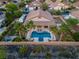 An aerial perspective of a backyard oasis featuring a pool, palm trees, and desert landscaping at 6245 Galileo Dr, Las Vegas, NV 89149